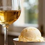 Verre de vin sauternes à côté d'une boule de glace vanille dans un bol, lumière naturelle et fond flou